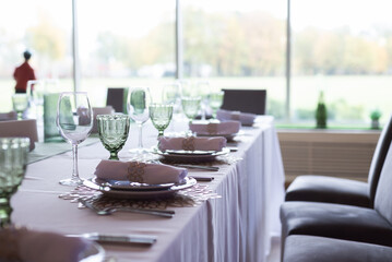 
Serving and decoration of the wedding table. Glasses, spoons, forks and white napkins