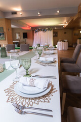 
Serving and decoration of the wedding table. Glasses, spoons, forks and white napkins