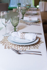 
Serving and decoration of the wedding table. Glasses, spoons, forks and white napkins