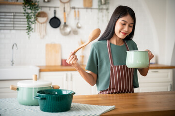 Young beauty asian woman cooking in kitchen room at home