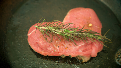 Heart shaped raw meat with rosemary isolated in a black background steel pan - Powered by Adobe
