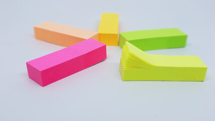 Post it or a colorful sticky note to mark pages in a book, magazine or newspaper isolated white