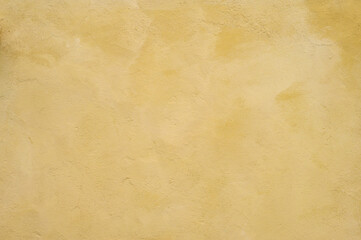 Textured wall in shades of yellow paint, as a graphic background
