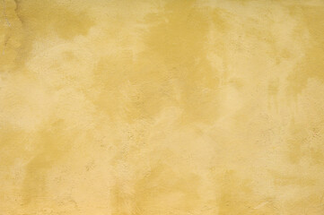 Textured wall in shades of yellow paint, as a graphic background
