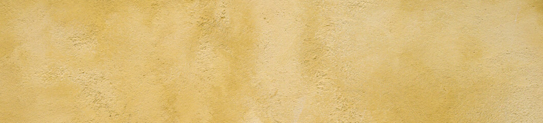 Textured wall in shades of yellow paint, as a graphic background
