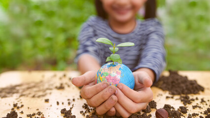 Banner of blurred  little girl is holding plant and globe model together, concept of ESG,...