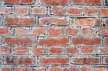 Old weathered and deteriorating brick wall, as a grungy background
