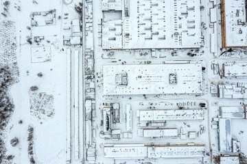 industrial area in winter. factory buildings and warehouses covered with snow. aerial top view.