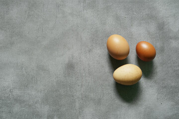 3 raw eggs on the concrete floor