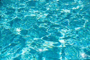 Background of blue water in swimming pool with sun reflection, ripple water wave in pool. Clear water background.