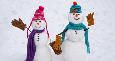 Snowman in hat and scarf on snowy field. Merry Christmas and happy new year greeting card with copy space.