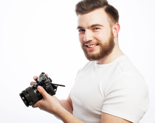 young bearded man wearing white t-shirt with a digital camera isolated on a white background