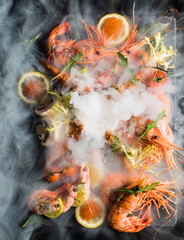 Obraz na płótnie Canvas shrimps on stone plate with smoke