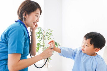 子どもを診察する若い看護師