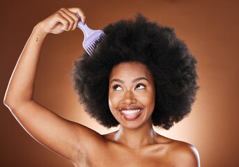 Beauty, hair care and black woman with afro comb in studio isolated on a brown background. Afro,...