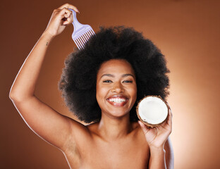 Black woman, hair care comb and coconut for beauty in studio isolated on brown background....