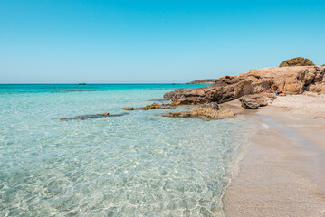 Elafonisi, crete island, greece: pink colored sandy beach with black rocks at the famous cretan...