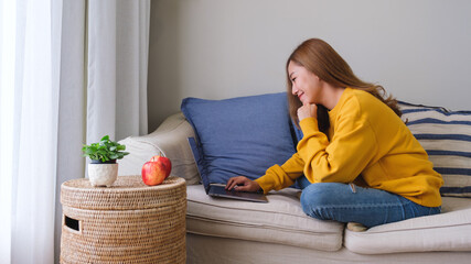 Portrait image of a young woman using laptop computer for working or studying online at home