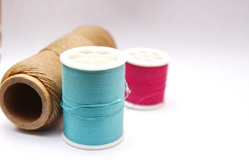 Green, red, brown spools placed on a white background.