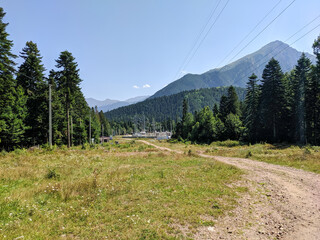 Arkhyz, Karachay-Cherkessia, Russia - August 24, 2022: View of the Caucasus Mountains and coniferous forest. The pedestrian road leads to the village of Arkhyz