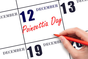 December 12. Hand writing text Poinsettia Day on calendar date. Save the date.