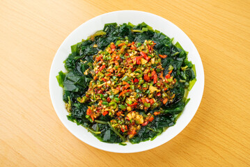 A plate of cold seaweed seedlings on a wooden table