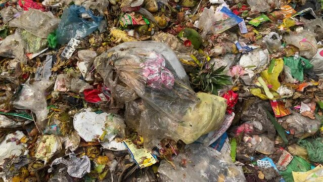 Panning over Endless piles of garbage and all forms plastic waste at rubbish dump
