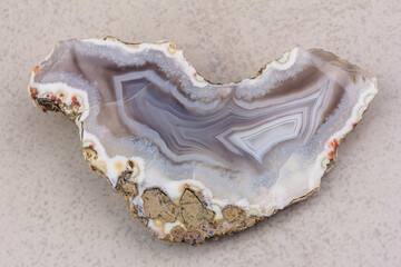 mineral gray agate in close-up section on a grey background - obrazy, fototapety, plakaty