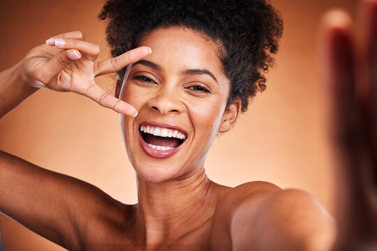 Black woman, peace sign and skincare beauty, selfie for wellness and natural makeup or cosmetics in studio background. A happy model with afro, face cosmetic, hand icon and self love empowerment