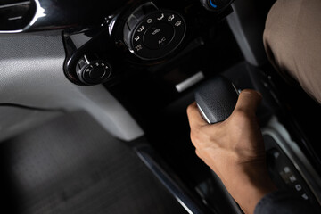 car driving concept The male driver switches to drive mode or shifts the car's gear.