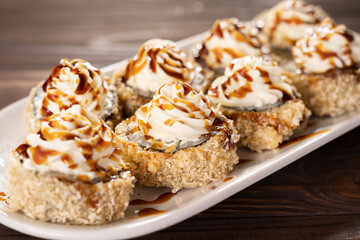 Hot tempura roll with salmon, shrimp and cheese, Traditional delicious fresh sushi roll set on a plate. Sushi menu. Japanese kitchen, restaurant.