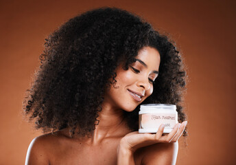 Beauty, haircare and product with a model black woman in studio on a brown background for treatment. Container, hair mask and wellness with an attractive young female posing to promote cosmetics