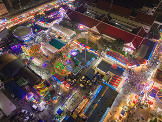 Aerial top view of amusement park in night temple fair, and night local markets. People walking street, Colorful tents in Bangkok city, Thailand. Retail shops
