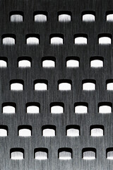 Extreme close-up shiny silver metal food grater light dark areas abstract dramatic cold alien...