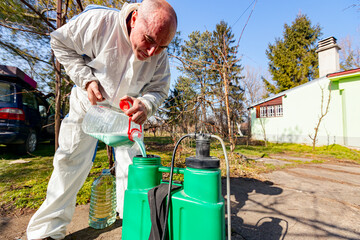 Gardener is blending substance with water in proper scale for sprinkles fruit trees