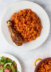 Ghana Jollof Rice With Chicken and a side of salad.
