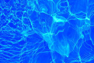 Fototapeta na wymiar Defocus blurred transparent blue colored clear calm water surface texture with splashes and bubbles. Trendy abstract nature background. Water waves in sunlight with copy space. Blue watercolor shining