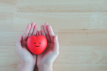 Heart and happy smiling face in hand. Emotion, Enjoy life, Positive thinking, Mental health...