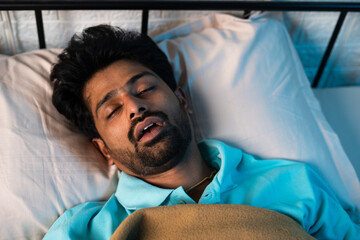 close up shot of man sleeping by snoring with mouth open during night - concept of relaxation,...