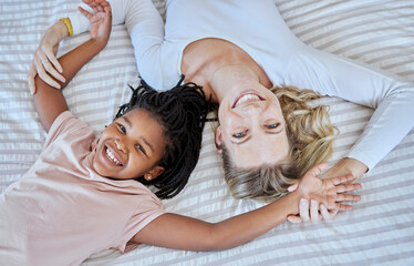 Mother, adoption and child lying on bed with smile for quality family bonding time together at...