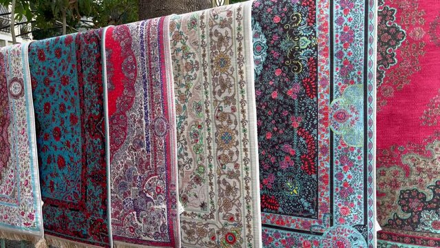 Colorful carpets hanging on street market for sale in Istanbul city. Traditional persian rugs in Turkey
