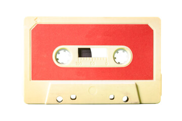 Isolated old vintage cassette tape from the 1980s (obsolete music technology). Dirty white yellowish plastic body and warm red label.

