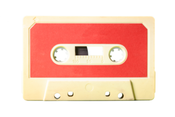 Isolated old vintage cassette tape from the 1980s (obsolete music technology). Dirty white yellowish plastic body and warm red label.
