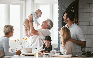 .Family, kitchen and grandpa playing with baby having fun, bonding and relax together. Big family,...