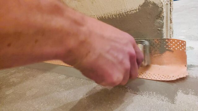 Paint a sealing tape the corners with flexible component sealing film. Making a waterproofing in the bathroom.