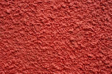 Home facade texture. Rough surface. Grunge grain. Crushed rocks in the wall. Exterior home decoration. Stucco wall pattern. Red color retro design. Noisy design background.