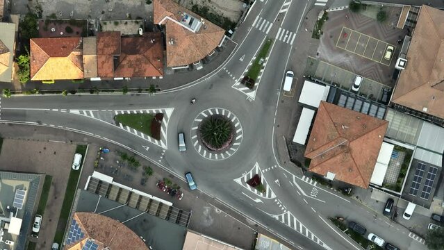 Aerial drone footage of a circle roundabout in the city of Nago-Torbole, Italy in daylight