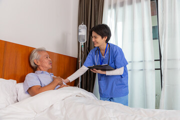 Female doctor or general practitioner listens to the woman and writes the information in retirement home. - 546492246