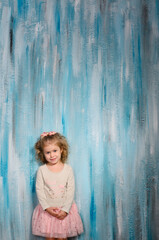 girl in a light jacket and a pink tutu skirt, stands against a blue wall in a watercolor style