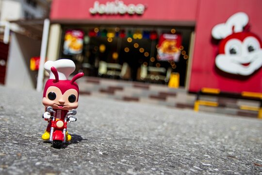 Jollibee figurine on a bike before the restaurant building